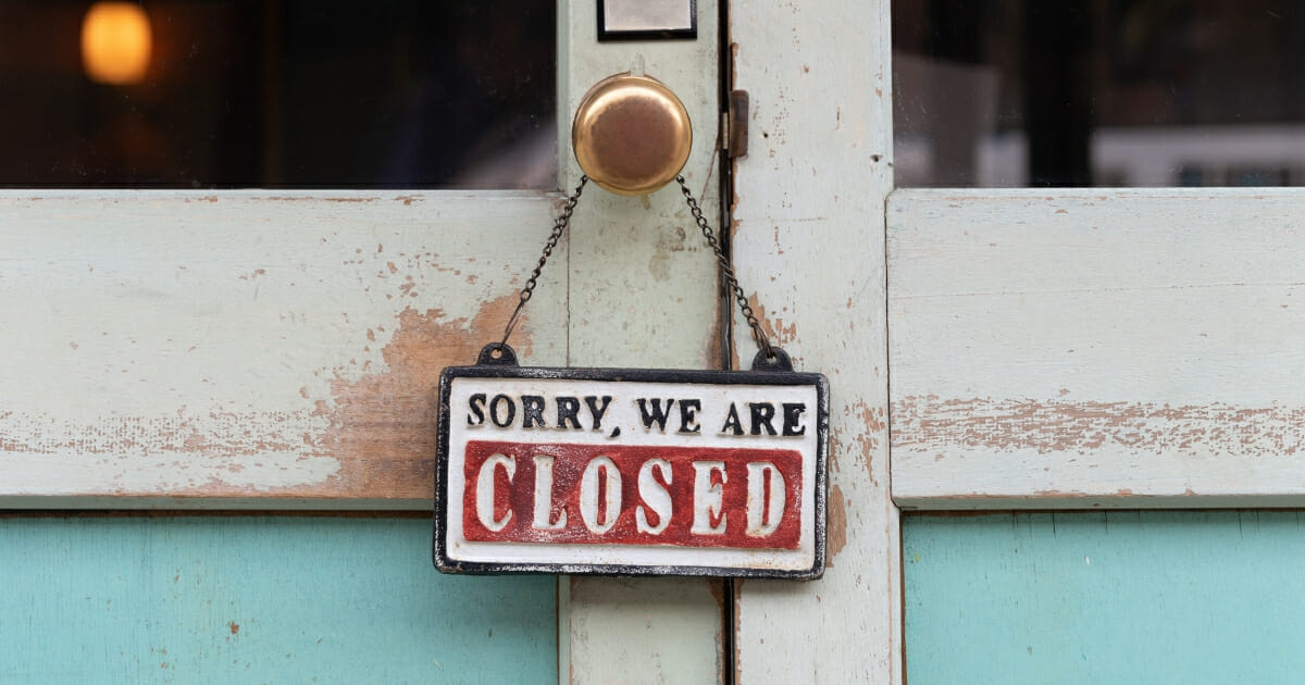 A "closed" sign hanging on a door.