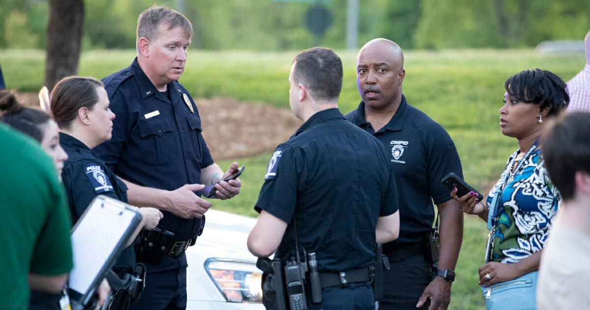Police officers consult after a shooting Tuesday on the campus of the University of North Carolina at Charlotte.