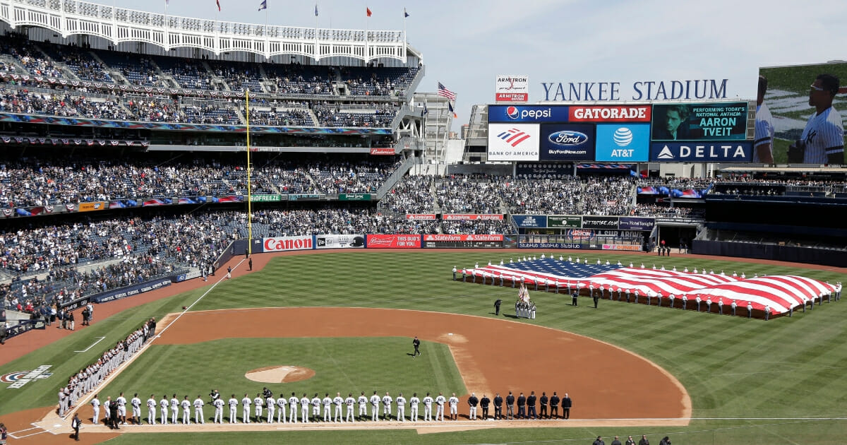 A large flag is unfurled during the national anthem before the New York Yankees' Opening day game against the Baltimore Orioles at Yankee Stadium on March 28, 2019.