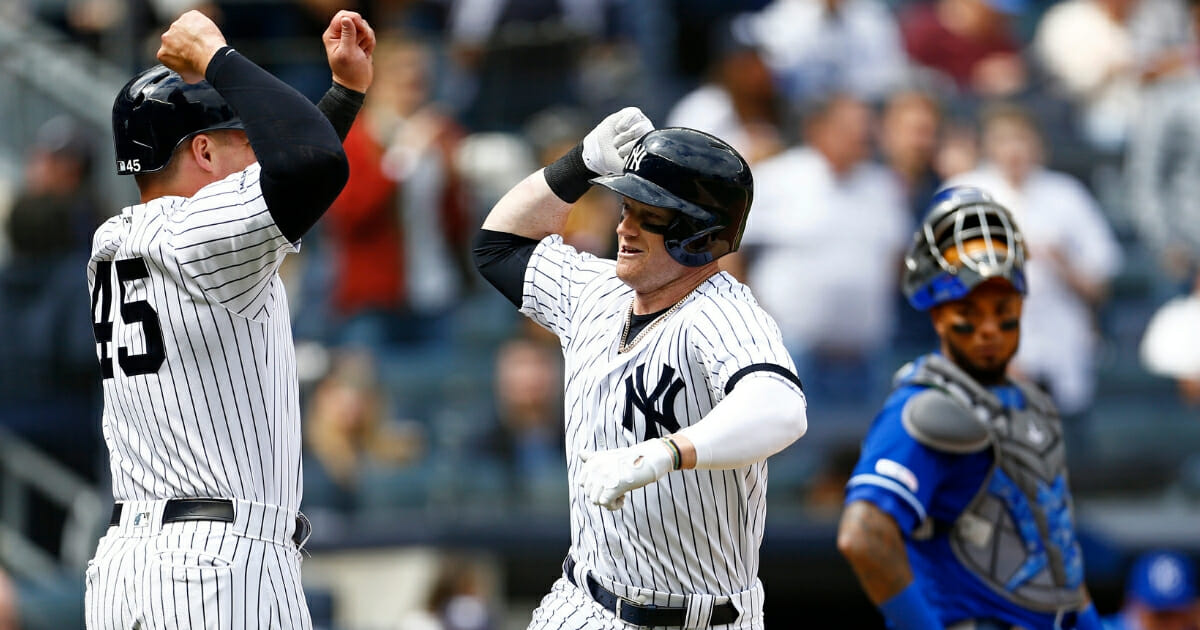 The New York Yankees' Clint Frazier, center, celebrates his three-run home run with Luke Voit in front of Kansas City Royals catcher Martin Maldonado on April 21, 2019.