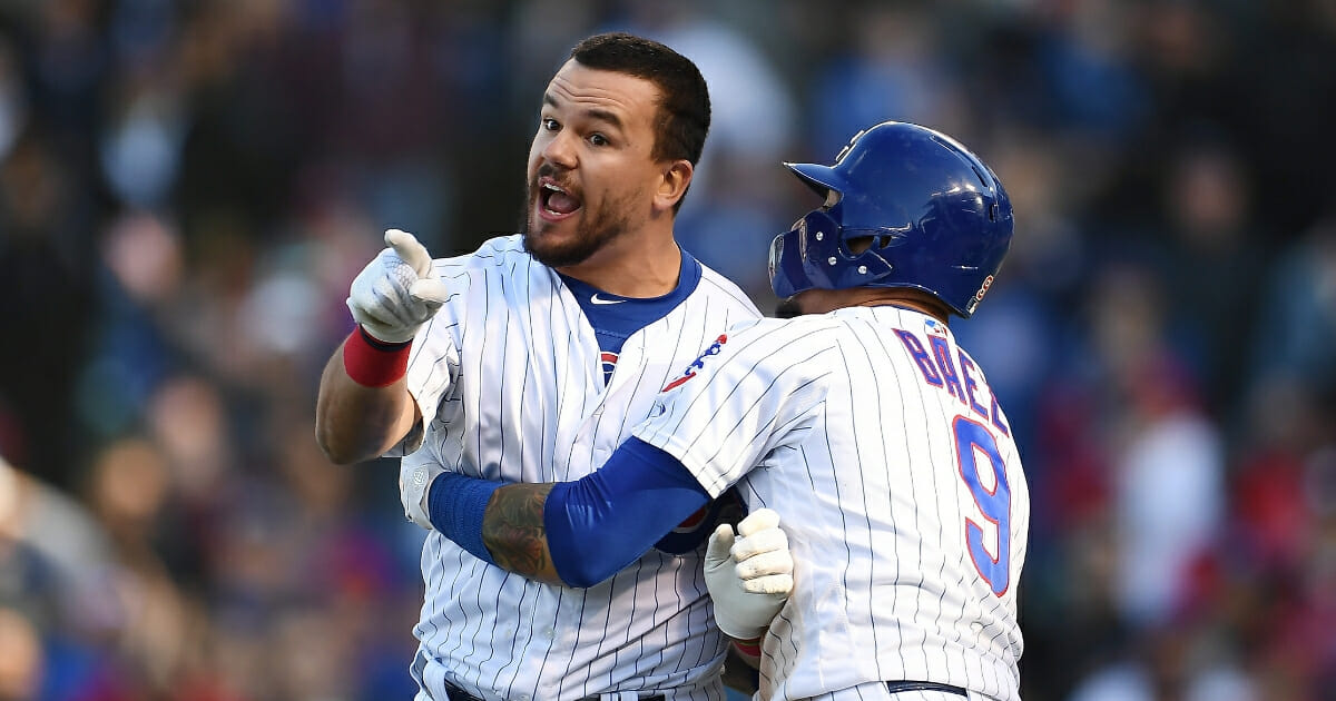 Kyle Schwarber of the Chicago Cubs is restrained by Javier Baez after being called out by the third base umpire during the ninth inning of a game against the Los Angeles Angels at Wrigley Field on April 13, 2019 in Chicago.