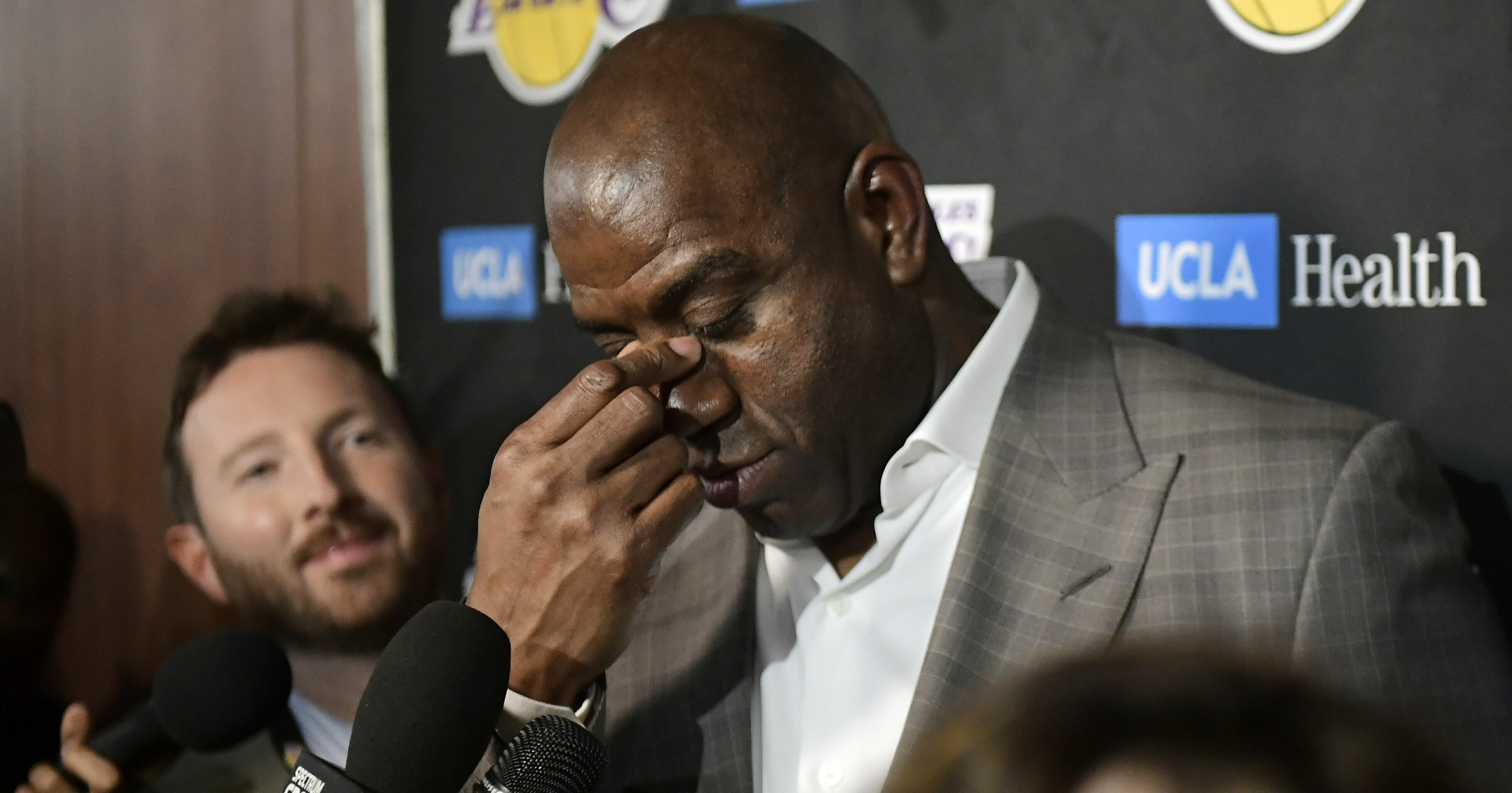 Magic Johnson wipes his eyes as he speaks to reporters prior to the Los Angeles Lakers game against the Portland Trail Blazers on April 9, 2019.