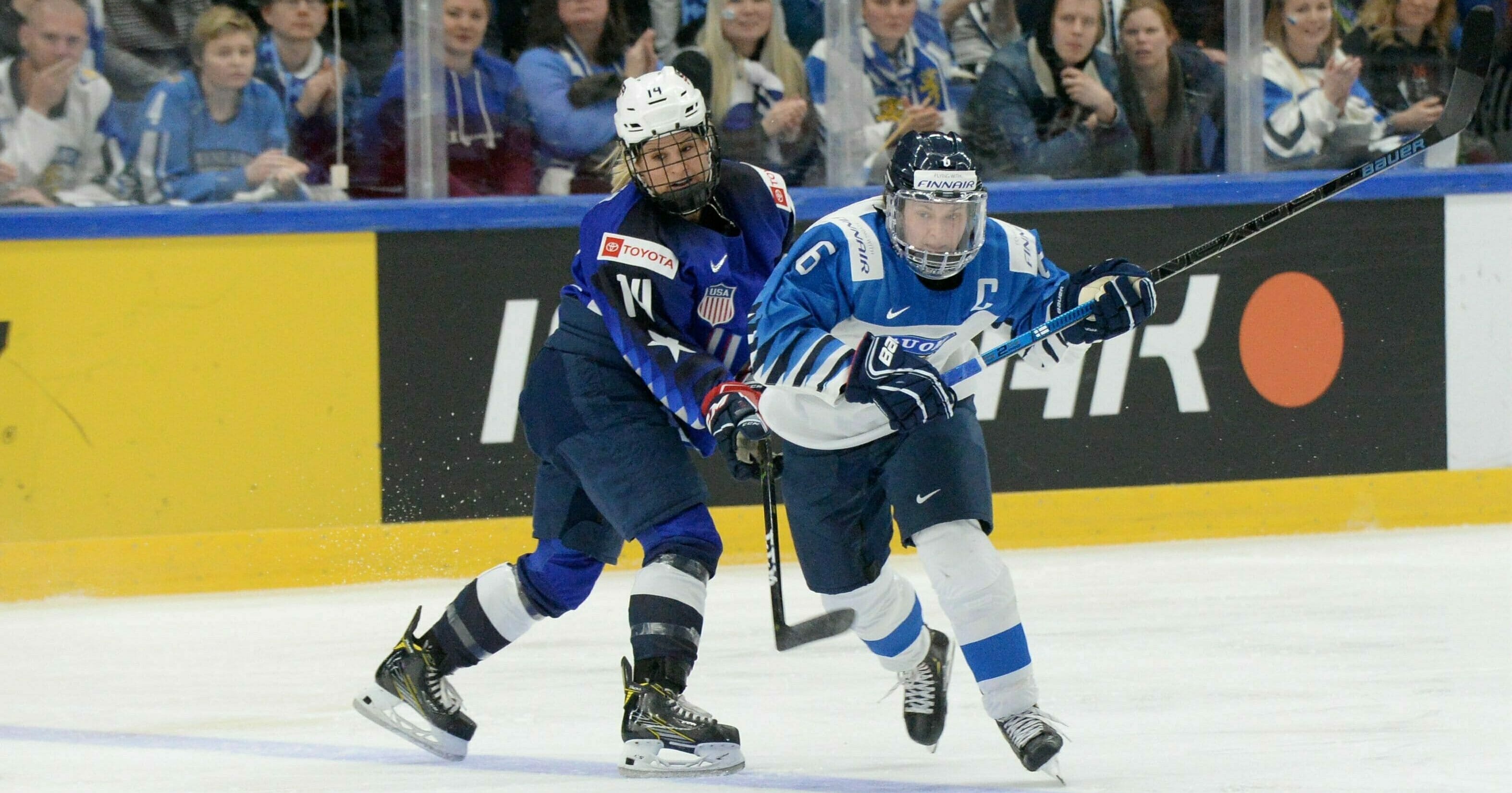 Brianna Decker, left, of the United States and Jenni Hiirikoski of Finland vie for the puck during the IIHF Women's Ice Hockey World Championships final match between the United States and Finland in Espoo, Finland, Sunday, April 14, 2019.