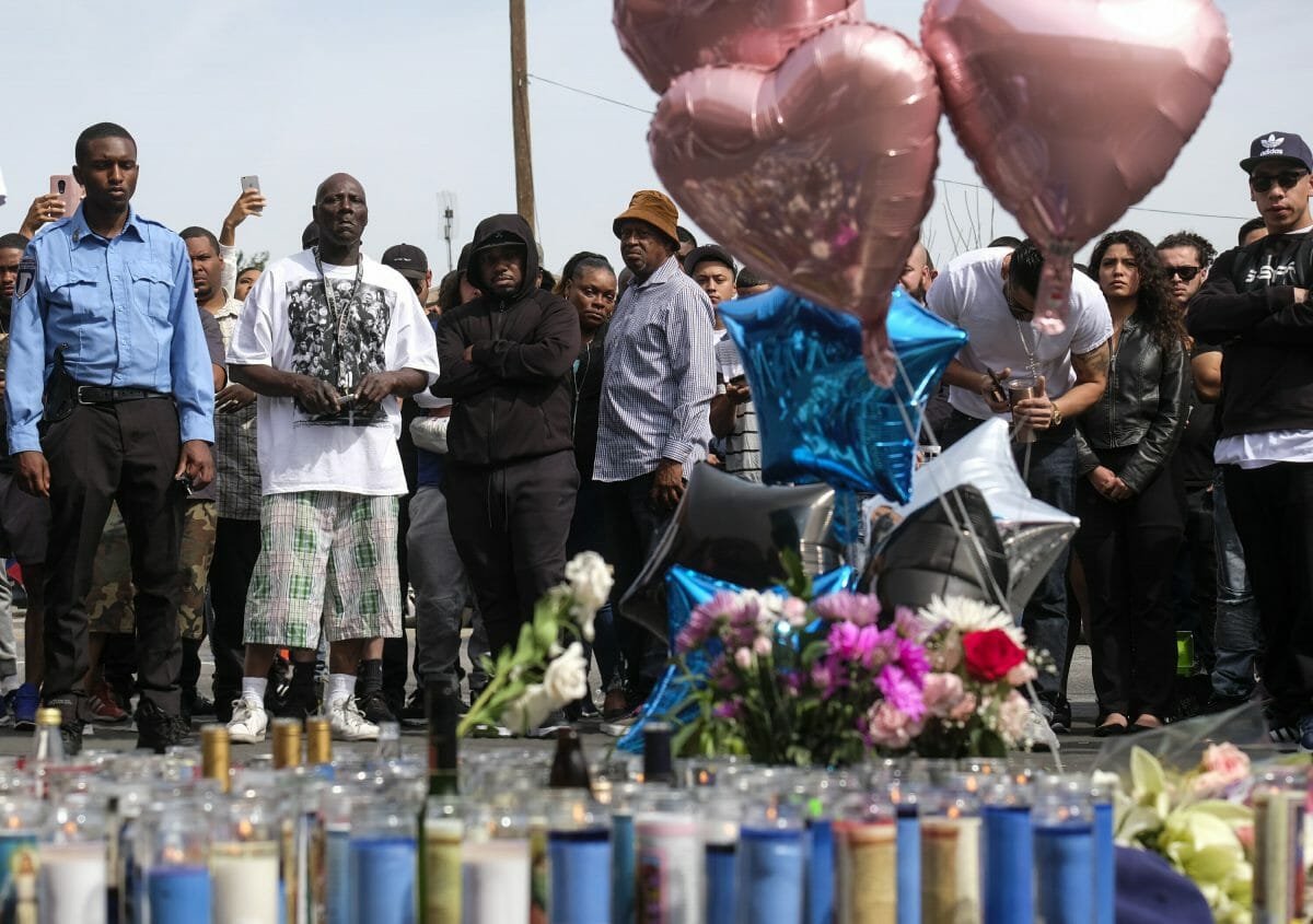 Fans of rapper Nipsey Hussle appear at a makeshift memorial in the parking lot of Hussle's Marathon Clothing store in Los Angeles, Monday, April 1, 2019. Hussle was killed in a shooting outside the clothing store on Sunday.