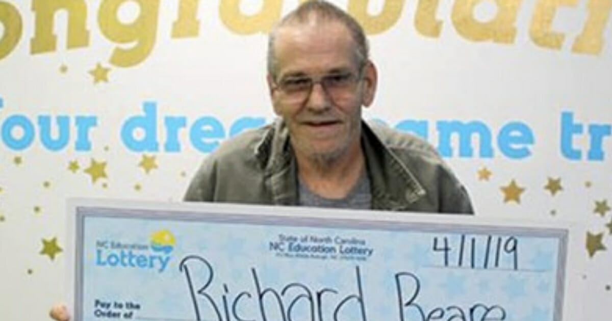 Man holds check of lottery winnings