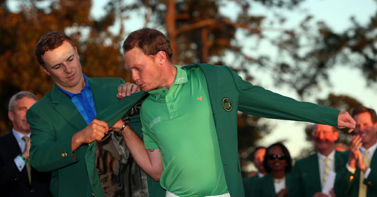 Jordan Spieth of the United States presents Danny Willett of England with the green jacket after Willett won the final round of the 2016 Masters Tournament at Augusta National Golf Club on April 10, 2016 in Augusta, Georgia.