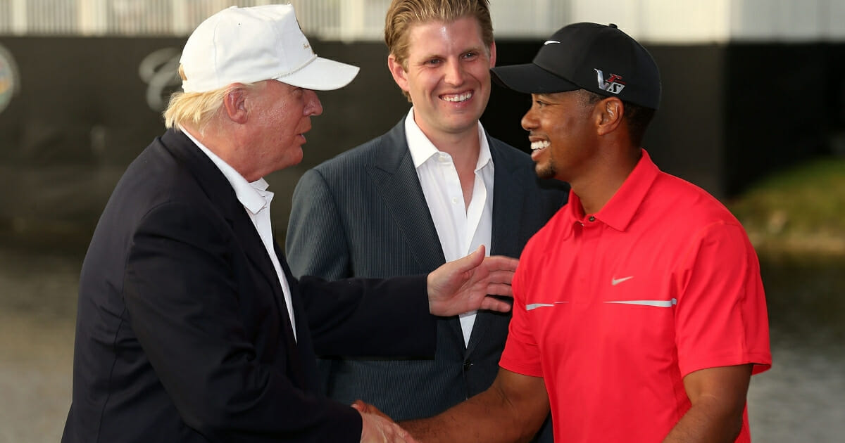 Donald Trump greets Tiger Woods after the final round of the World Golf Championships-Cadillac Championship as Eric Trump looks on at the Trump Doral Golf Resort & Spa on March 10, 2013 in Doral, Florida.