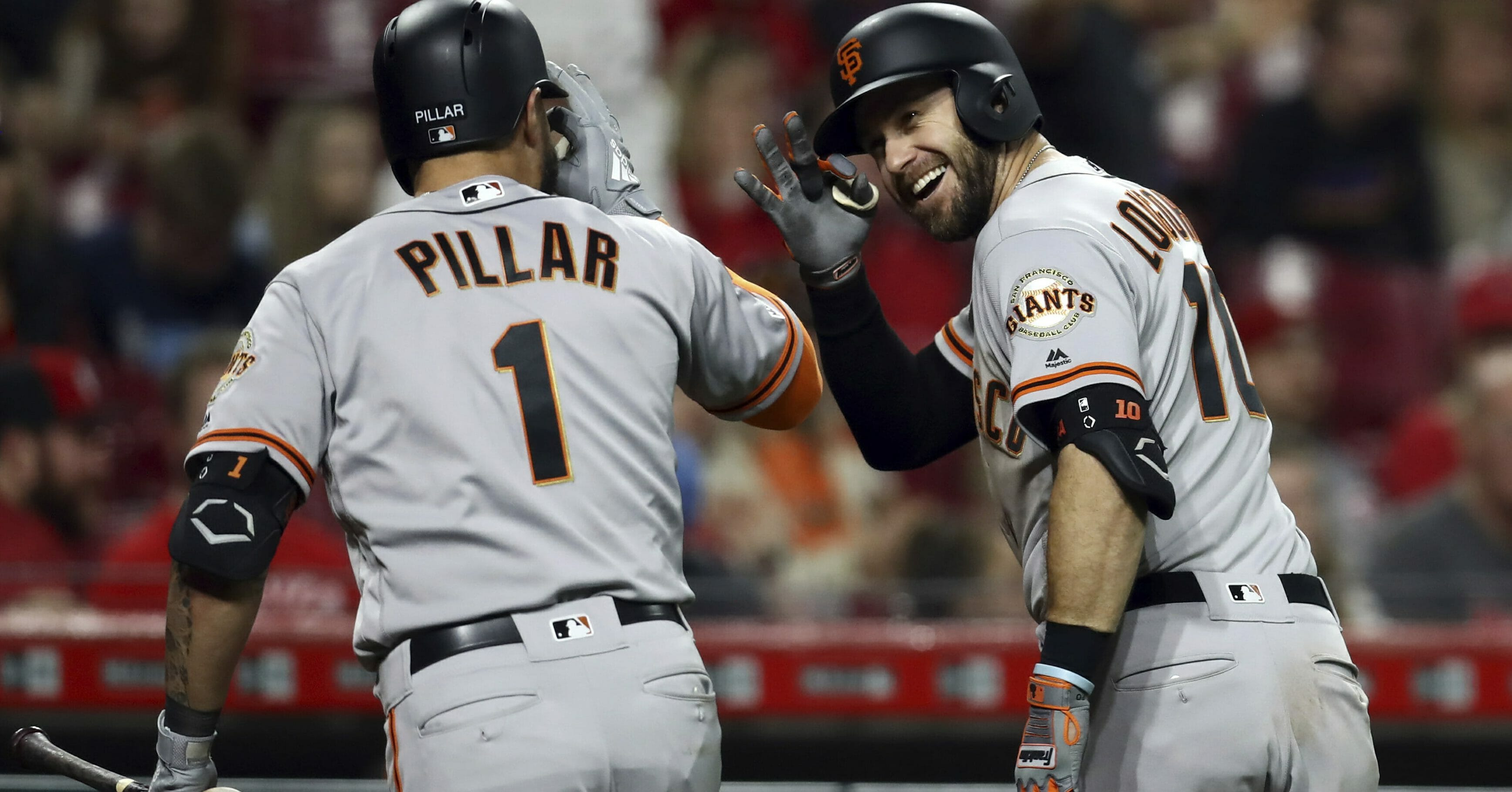San Francisco Giants' Evan Longoria celebrates with Kevin Pillar after hitting a home run for the go-ahead run in the 11th inning against the Cincinnati Reds on Friday, May 3, 2019, in Cincinnati.