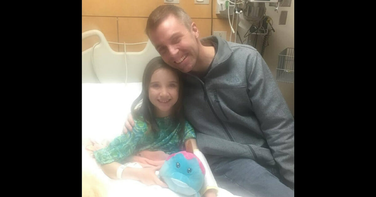 A little girl and her pastor smile in the hospital.