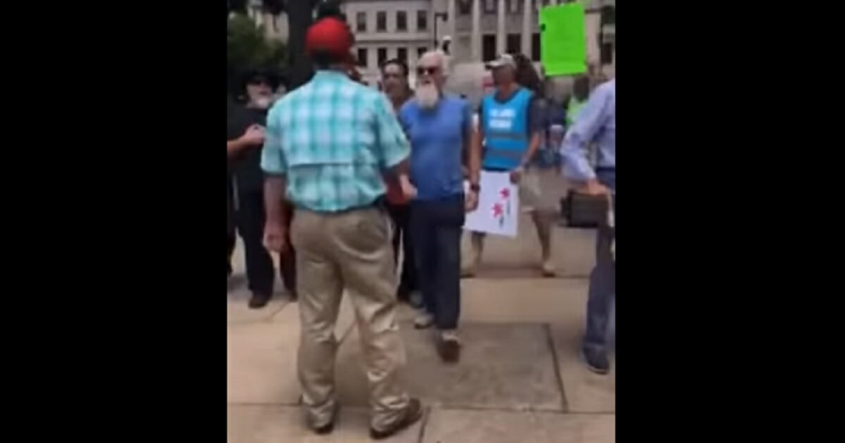 A crowd of pro-abortion demonstrators approaches a pro-life protester in Mississippi.