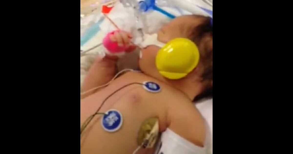 Baby in hospital with tubes sticking out.