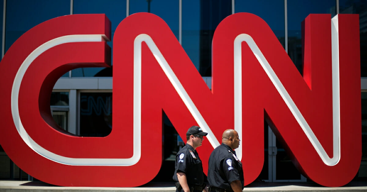 In this Aug. 26, 2014 file photo, security guards walk past the entrance to CNN headquarters in Atlanta. (David Goldman / AP Photo)