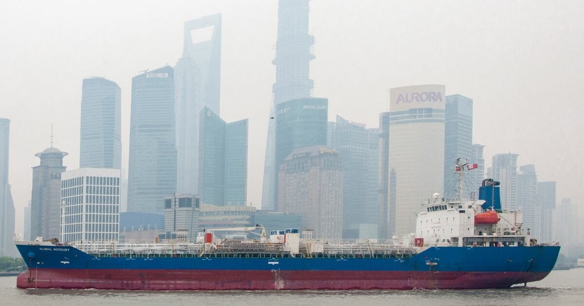 A cargo ship sails past skyscrapers of Shanghai in June 2013.