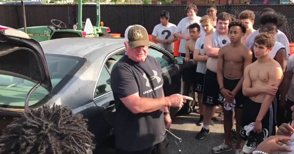 Steve Carter, an assistant at Athens High School in Alabama, teaches players how to change a tire on a "Manly Monday."