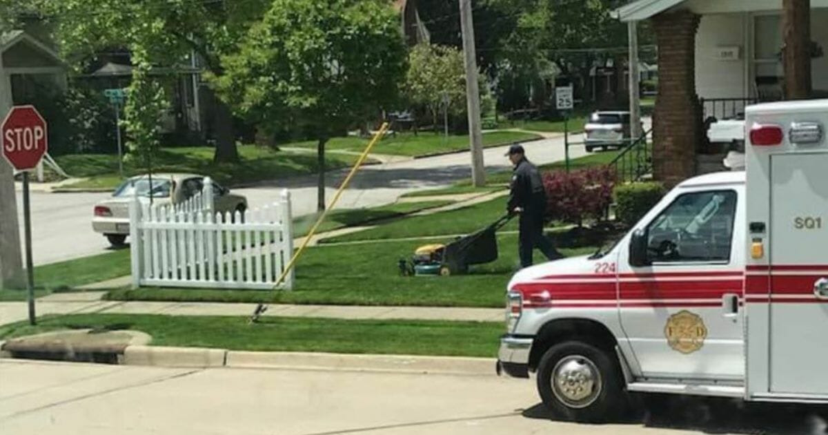 Firefighter mows lawn.