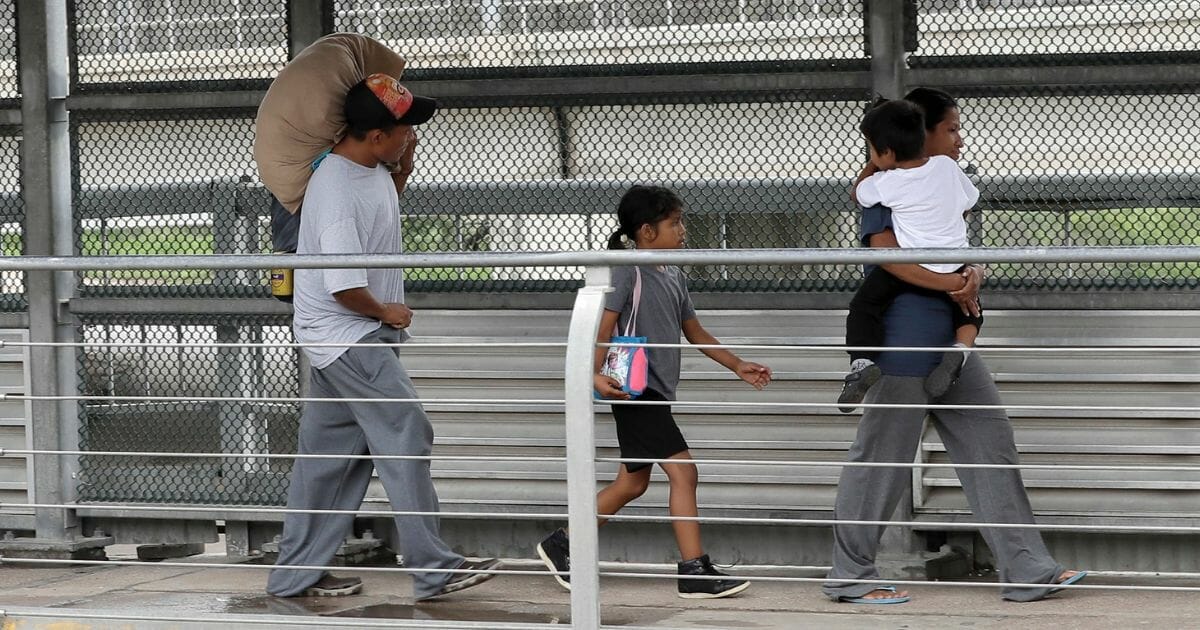 Immigrants from Honduras walk back across the U.S. southern border on June 21, 2018, in Hidalgo, Texas.