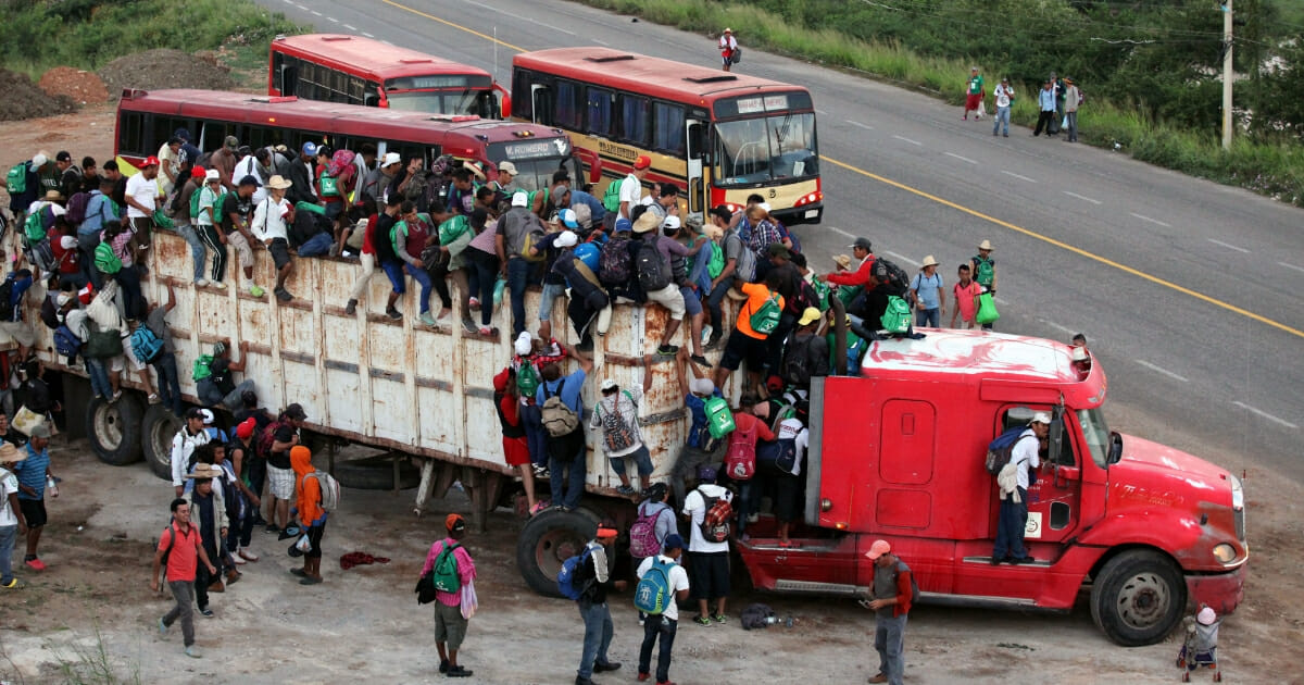 Hondurans among a caravan to the U.S. climb aboard a truck at dawn on Nov. 8, 2018, in Oaxaca, Mexico.