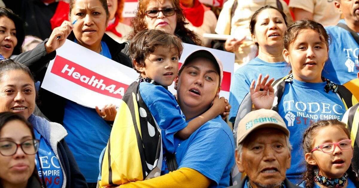 Oralia Sandoval, center, holds her son Benjamin, 6, as she participates in an Immigrants Day of Action rally, Monday, May 20, 2019, in Sacramento, California.