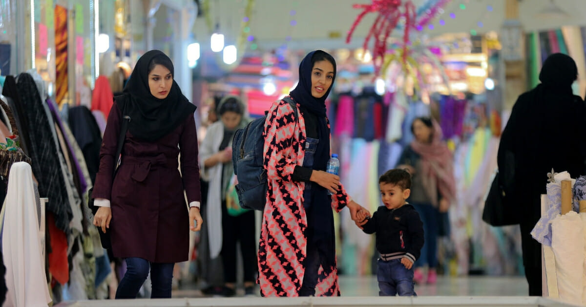Iranian women walk in a fabric shop in Tehran's old Tajrish Bazaar on April 23, 2019.