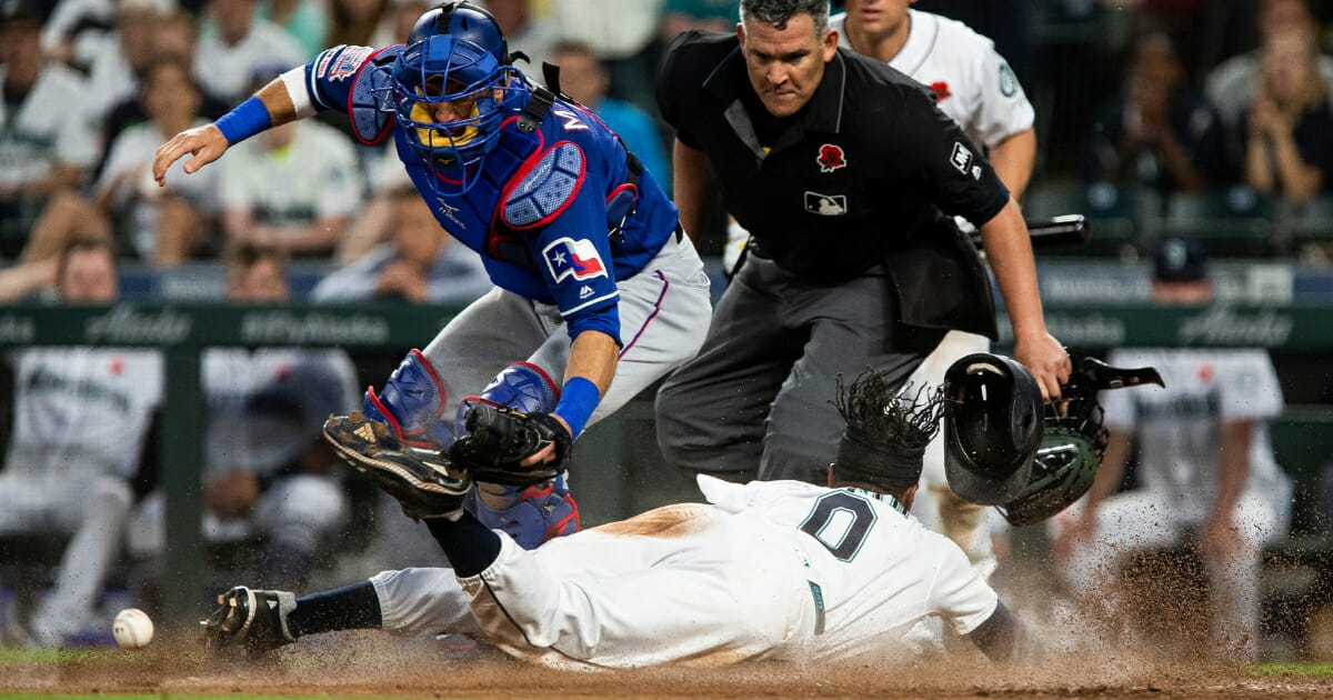 Mallex Smith of the Seattle Mariners slides home against the Texas Rangers.