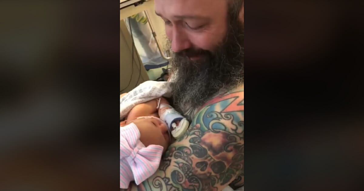 Dad holds newborn daughter for the first time.