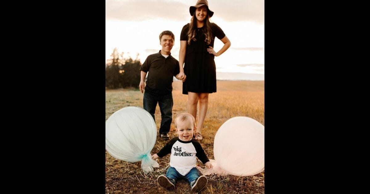 Zach and Tori Roloff, with Jackson sitting in front wearing a "big brother" shirt.