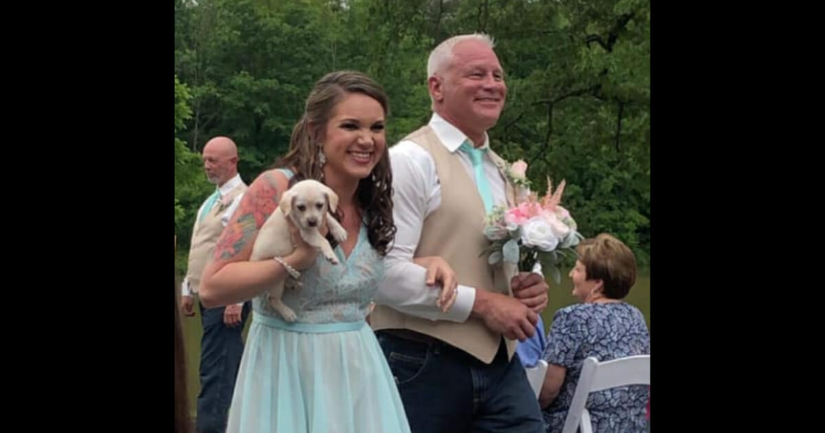 Bridesmaid holds puppy.