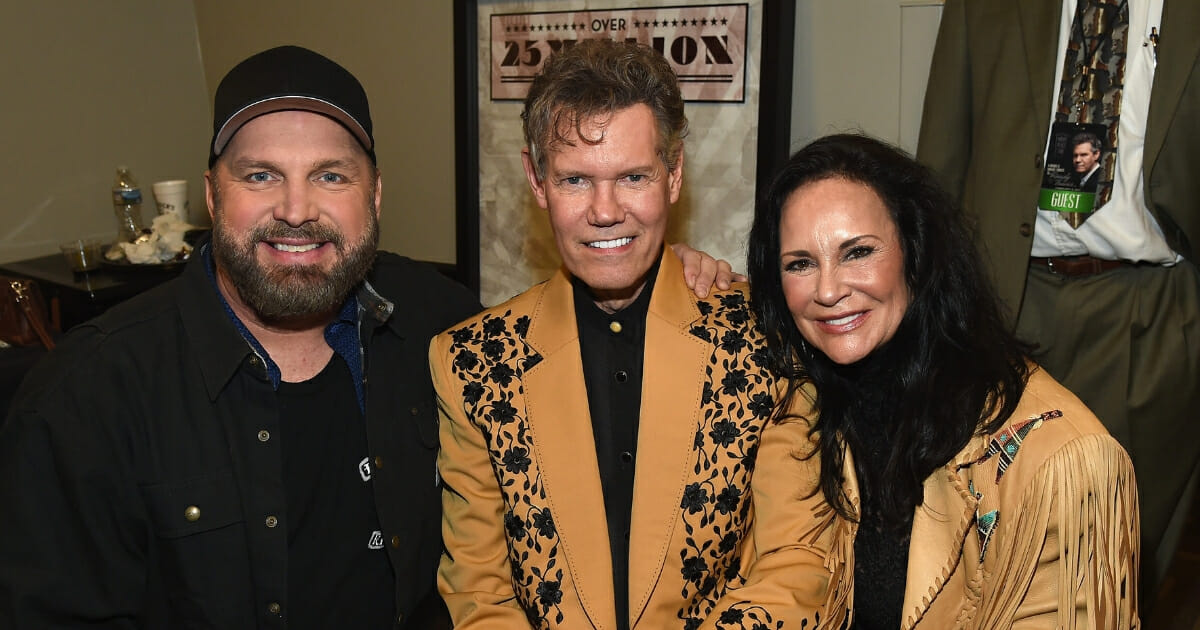 Garth Brooks standing with Randy and Mary Travis.