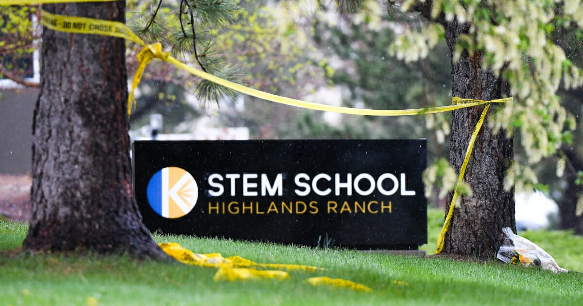 A bouquet of flowers is left next to the entrance to the STEM School Highlands Ranch
