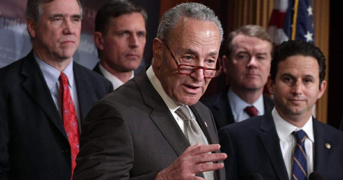 Senate Minority Leader Sen. Chuck Schumer, of New York, center, speaks at a news conference with Democratic colleagues, from left to right, Jeff Merkley of Oregon, Martin Heinrich of New Mexico, Michael Bennet of Colorado and Brian Schatz of Hawaii.