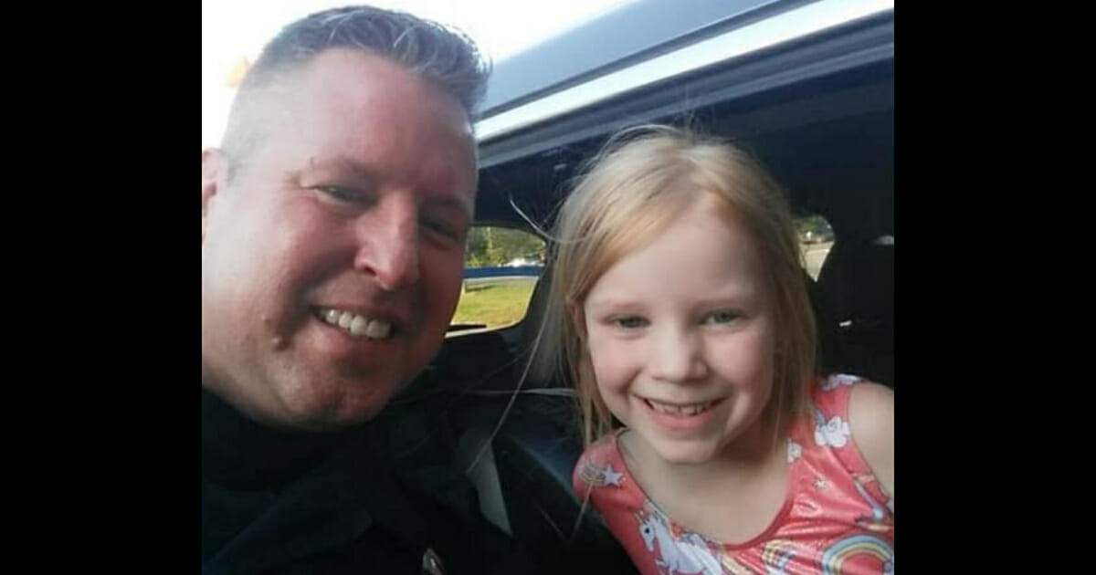 Cop and girl smiling.