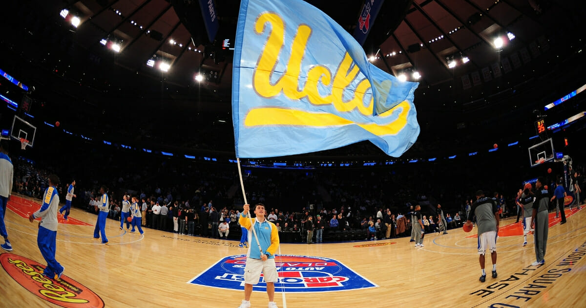 A cheerleader of the UCLA Bruins waves a flag against the Duke Blue Devils during the CARQUEST Auto Parts Classic at Madison Square Garden on Dec. 19, 2013 in New York City.