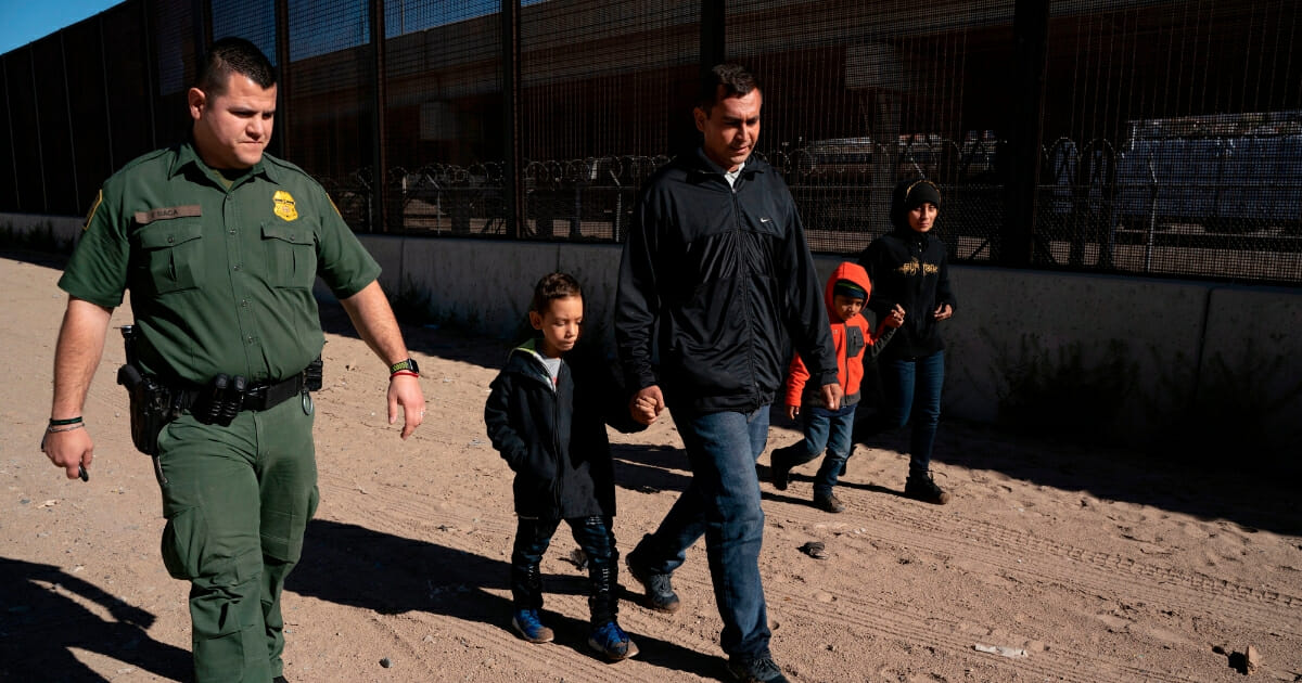 A family from El Salvador walks with a Border Patrol agent after crossing the Rio Grande to claim asylum in El Paso, Texas, in March.