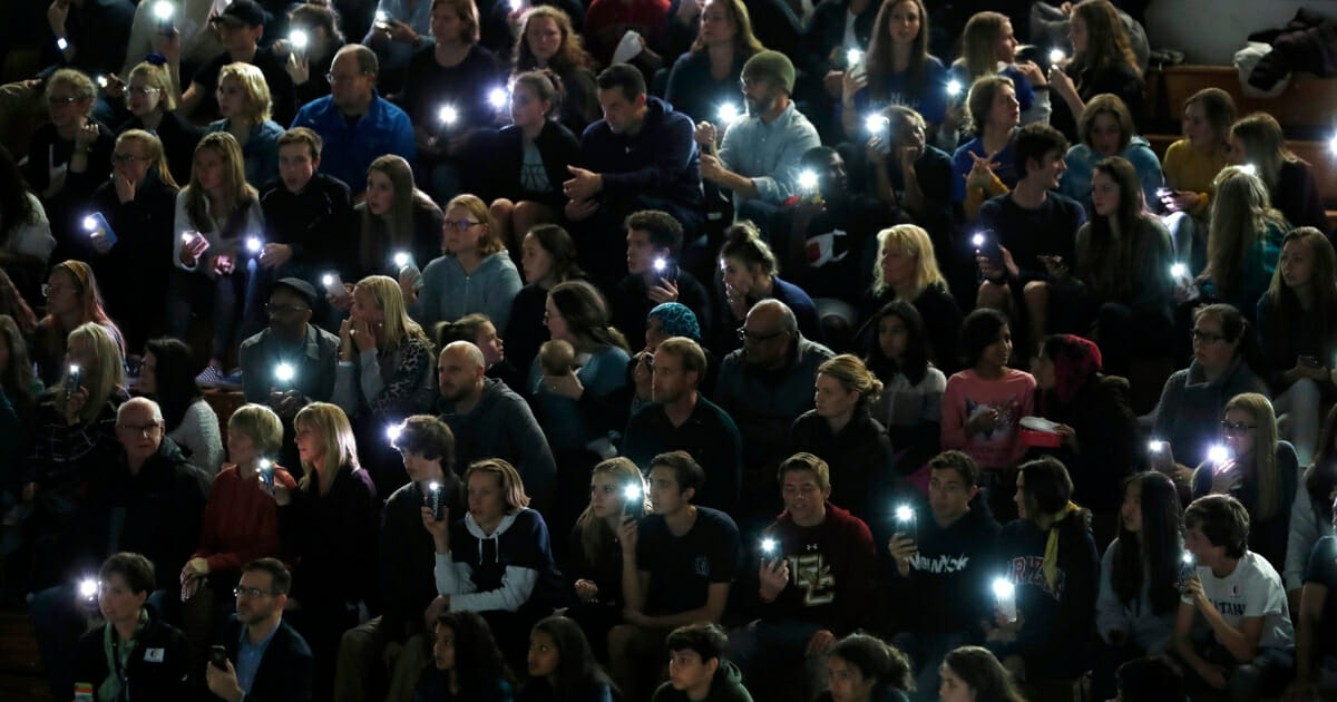 Attendees illuminate their mobile telephones during a community vigil to honor the victims and survivors of yesterday's fatal shooting at the STEM School Highlands Ranch, late Wednesday, May 8, 2019, in Highlands Ranch, Colorado.