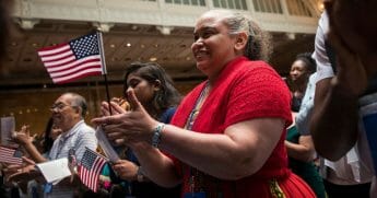 New U.S. citizens cheer after reciting the Oath of Allegiance during naturalization ceremony at the New York Public Library.