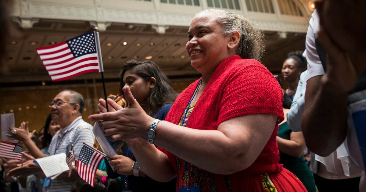 New U.S. citizens cheer after reciting the Oath of Allegiance during naturalization ceremony at the New York Public Library.