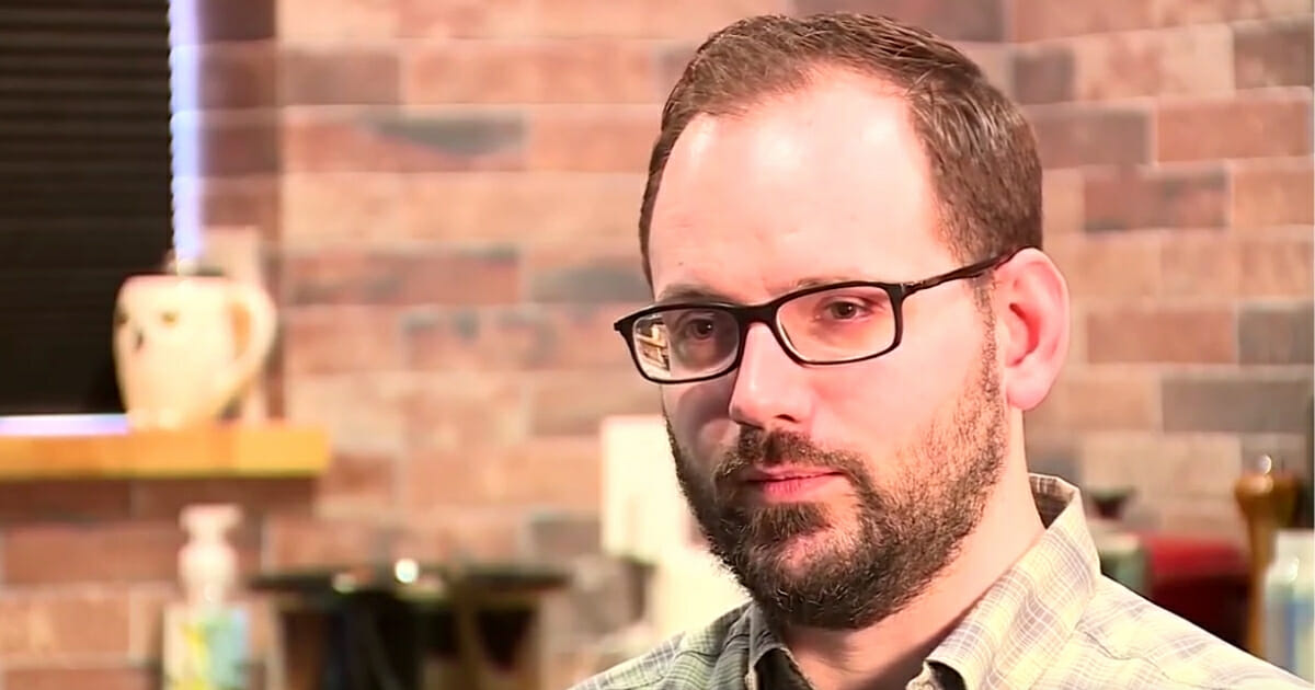 A man with a beard and glasses speaking to a camera.
