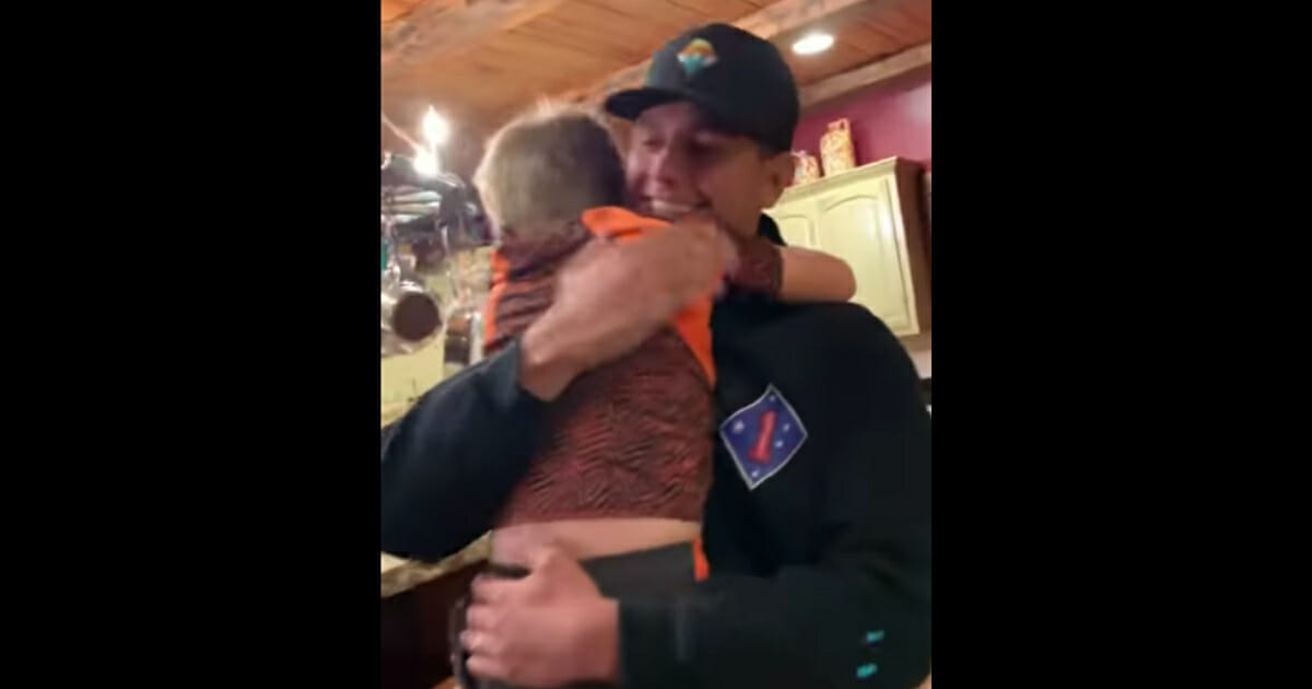 A younger brother hugs his older brother who is home from the military.