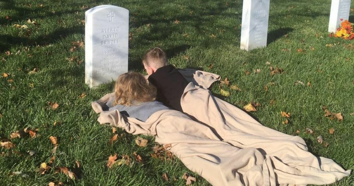 Two boys next to their dad's grave.