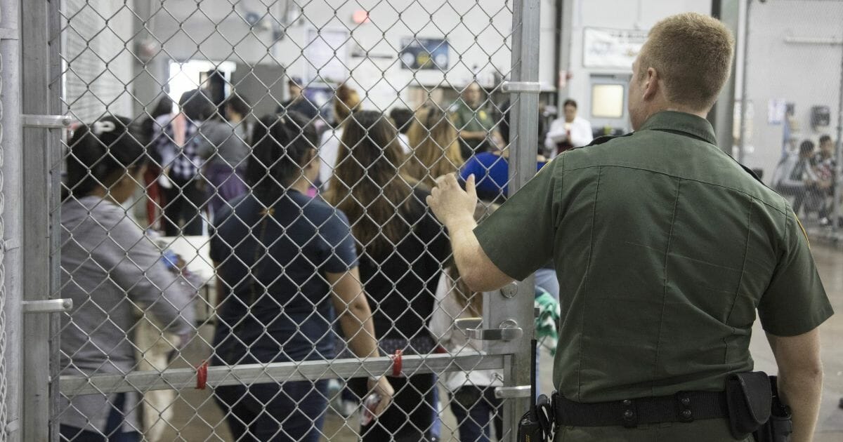 U.S. Border Patrol agents with captured southern border crossers at the Central Processing Center in McAllen, Texas, on June 17, 2018.