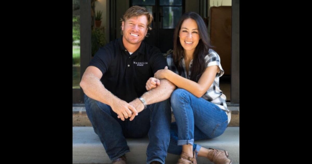 Chip and Joanna Gaines sitting on a porch.