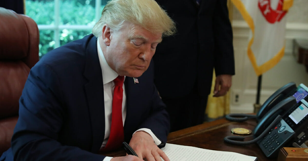 President Donald Trump signs an executive order imposing new sanctions on Iran in the Oval Office at the White House on June 24, 2019 in Washington, D.C.