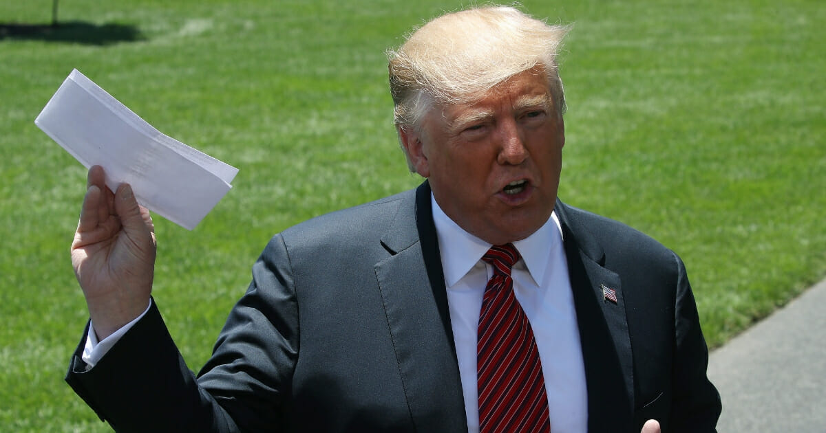 President Donald Trump holds a piece of paper he said was a trade agreement with Mexico while speaking to the media before departing from the White House on June 11, 2019 in Washington, D.C.