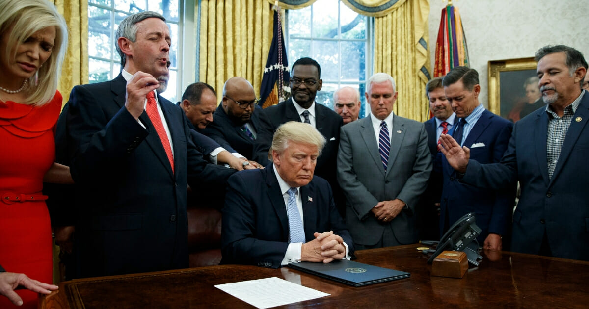 In this Sept. 1, 2017 file photo, religious leaders pray with President Donald Trump after he signed a proclamation for a national day of prayer to occur on Sept. 3, 2017, in the Oval Office of the White House in Washington.