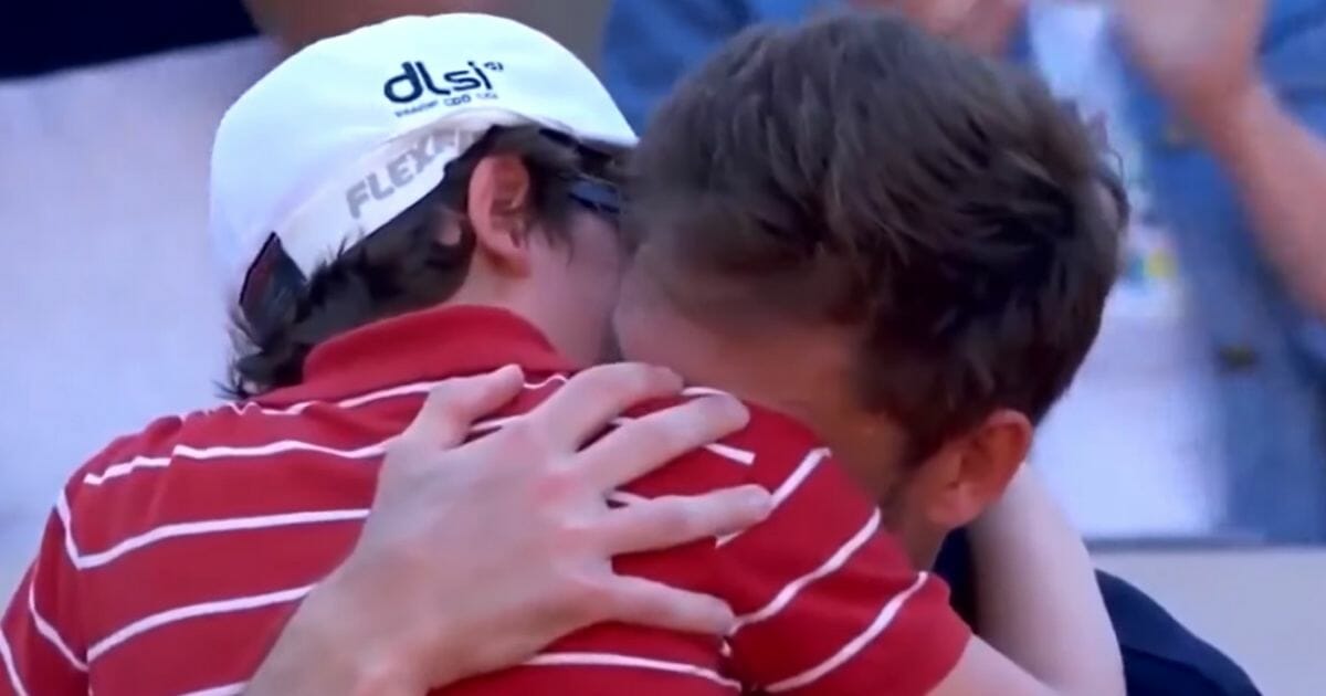 Father and son embracing on the court.
