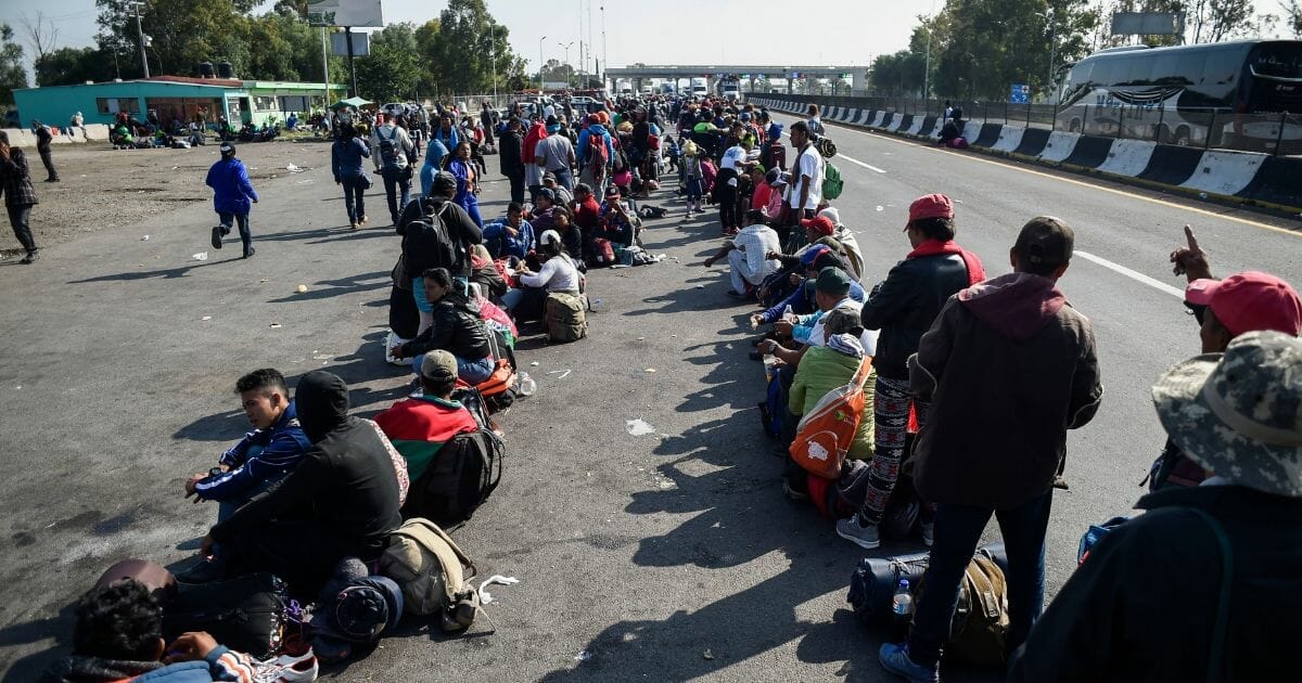 Central American migrants taking part in a caravan to the U.S., queue along the highway to get a ride to Irapuato in the state of Guanajuato on Nov. 11, 2018.