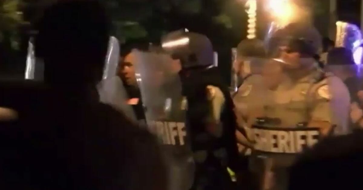 Memphis police officers confront rioters Wednesday, June 12, 2019, in Memphis, Tenn.