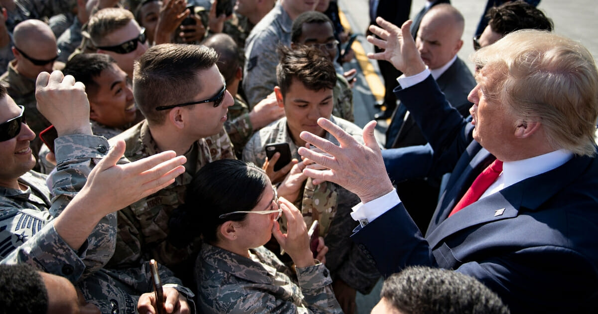 President Donald Trump greets troops as Air Force One is refueled at Elmendorf Air Force Base while traveling to Japan on June 26, 2019, in Anchorage, Alaska.
