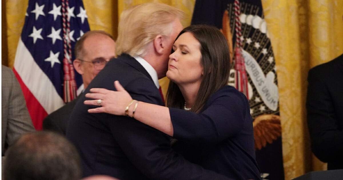 Outgoing White House press secretary Sarah Huckabee Sanders hugs President Donald Trump during a second chance hiring and criminal justice reform event in the East Room of the White House in Washington, D.C. on June 13, 2019.