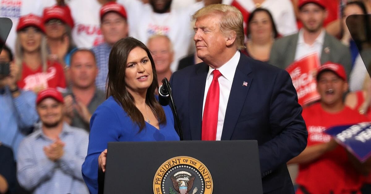 President Donald Trump stands with Sarah Huckabee Sanders, who announced that she is stepping down as the White House press secretary, during his rally where he announced his candidacy for a second presidential term at the Amway Center on June 18, 2019, in Orlando, Florida.